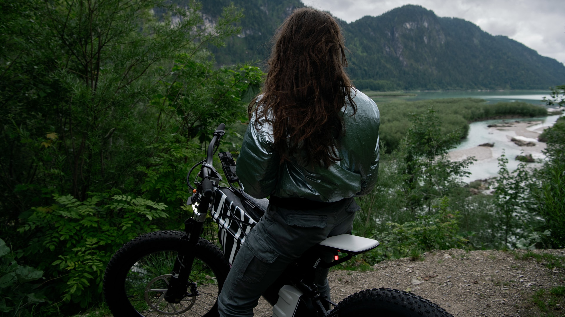 Femme assise sur une Vision AMBY avec vue sur un lac de montagne.