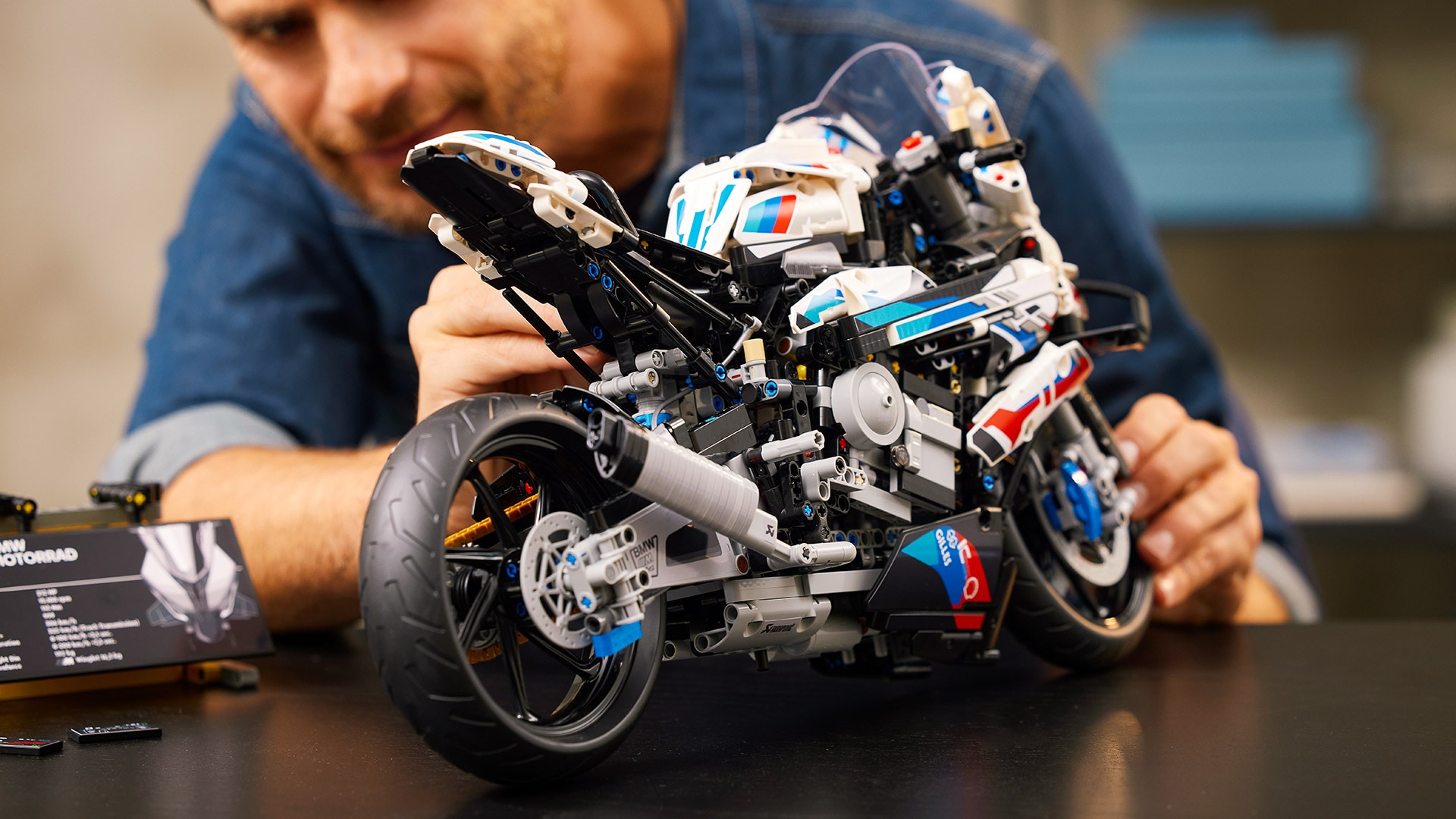 Un homme construit la M RR LEGO Technic.