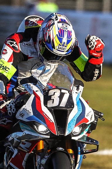 Conducteur d'une moto de course BMW Motorrad avec le poing serré.